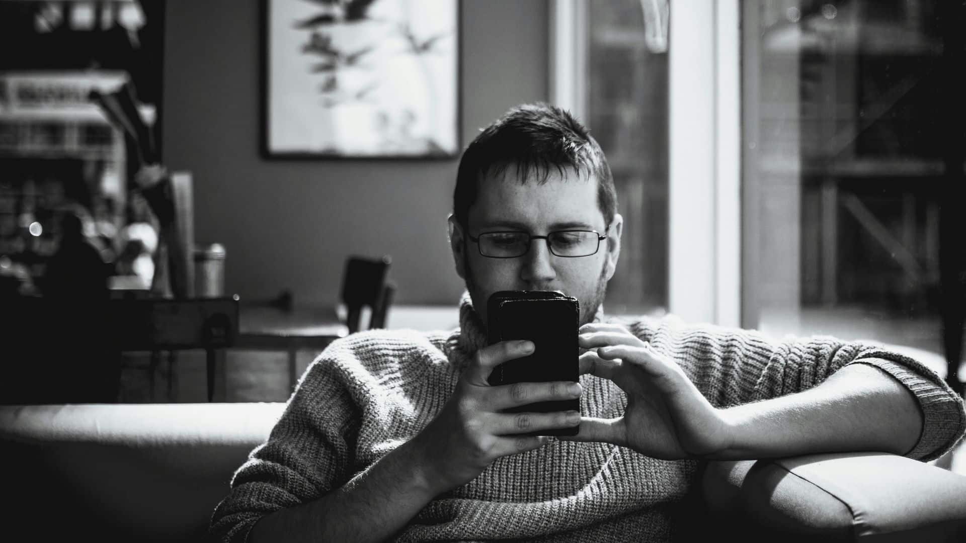 man scrolling the news on his phone